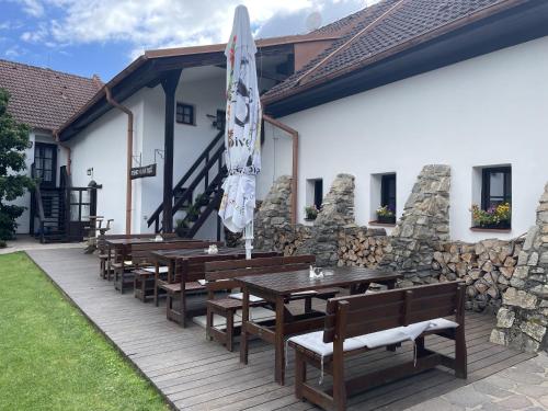 a patio with wooden tables and an umbrella at Wellness Hotel Svachovka in Český Krumlov