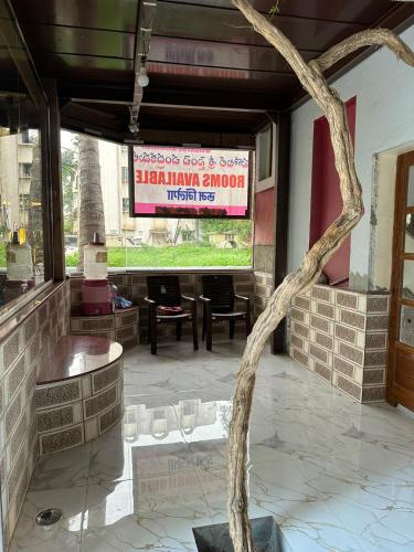 un albero al centro di un ristorante con un cartello di Chandrakamal a Shirdi