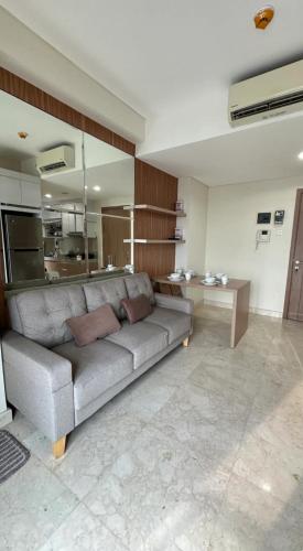 a living room with a couch and a table at Apt Puri Orchard at puri in Jakarta