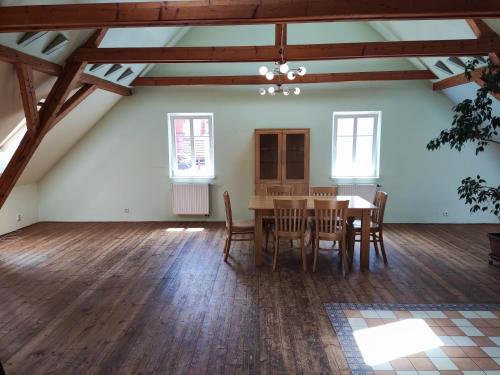 een zoldereetkamer met een tafel en stoelen bij Penzion U Lucerny in Jindrichuv Hradec