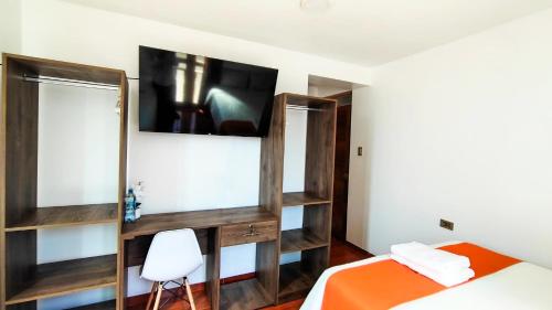 1 dormitorio con 1 cama y TV en la pared en Golden Paris Hotel "Mes de Aniversario", en Ayacucho