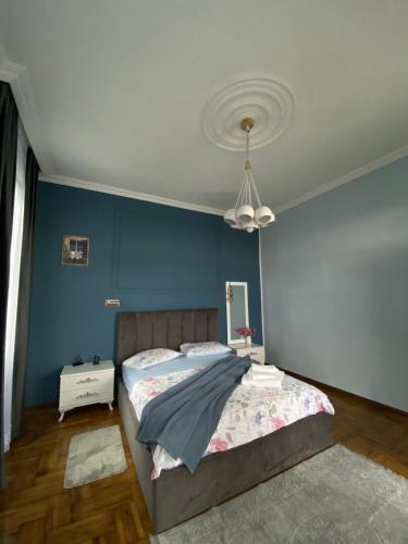 - une chambre avec un lit et un mur bleu dans l'établissement Horizon Hills - ჰორიზონ ჰილს, à Kvariati