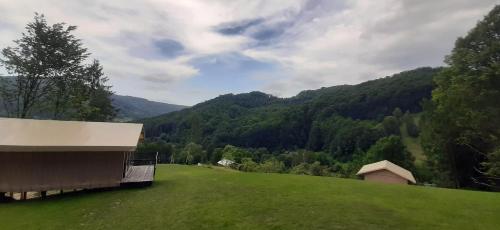 een grasheuvel met een gebouw en een berg bij AЖ у НЕБІ in Vizhenka