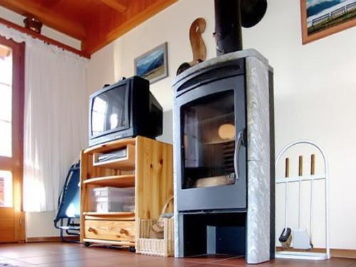 a living room with a fireplace and a tv at Cosy Apartment in Bellwald 68 m² Mountain View in Bellwald