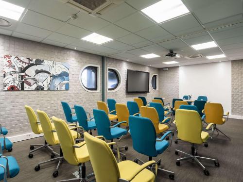 uma sala de conferências com cadeiras e uma televisão em Mercure Paris Gare De Lyon TGV em Paris