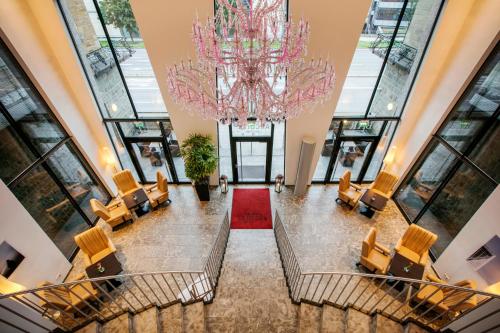 a large lobby with a chandelier and chairs at ARCOTEL Camino Stuttgart in Stuttgart