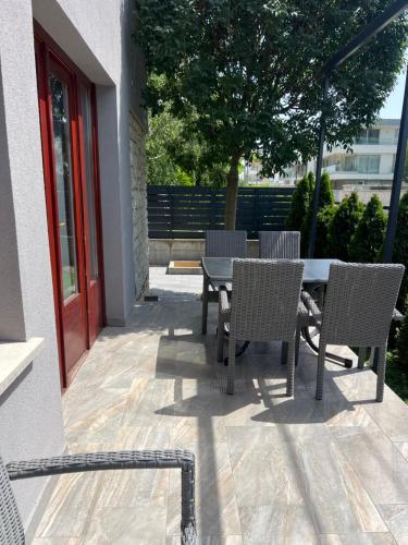 d'une terrasse avec des chaises, une table, une table et des chaises. dans l'établissement Hullám Apartman, à Balatonlelle