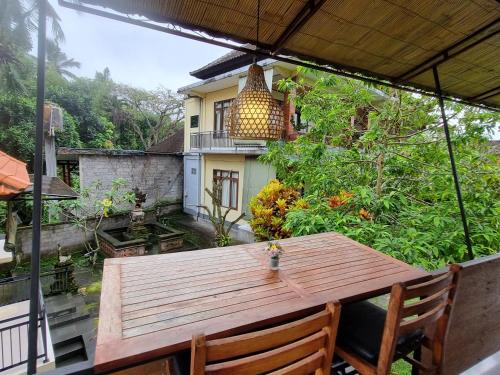 un tavolo in legno sul balcone di una casa di Nyoman Sandi Guest House ad Ubud