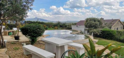 einen Pool in einem Garten mit einer Bank in der Unterkunft Homely Cottage Near Lake Naivasha, Elwai Visitor Centre in Heni Village