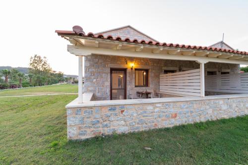 a small stone house with a porch on a field at Aktaion Resort in Gythio