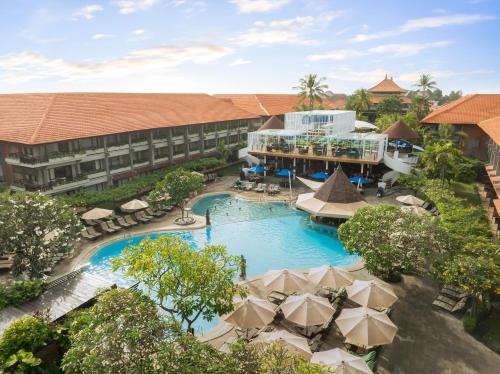 an aerial view of a resort with a pool and umbrellas at Bali Dynasty Resort in Kuta