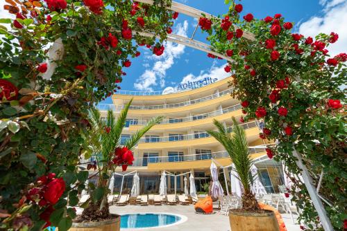 un hotel con fiori di fronte a un edificio di Aphrodite Beach Hotel a Nesebar