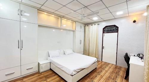 een slaapkamer met een wit bed en een raam bij Divya Anubhuti Pravas in New Delhi