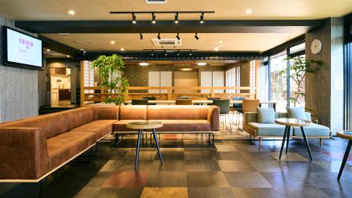 a lobby with a couch and tables and chairs at COGO TENNOJI in Osaka