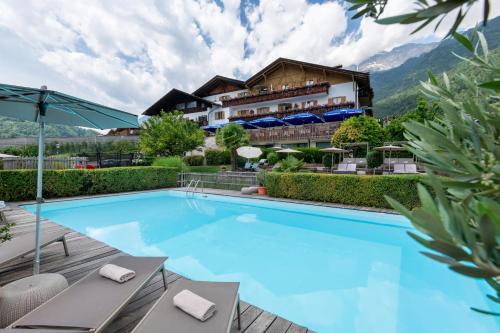 une piscine dans un hôtel avec des montagnes en arrière-plan dans l'établissement Hotel Residence MaVie, à Lagundo