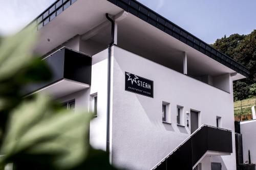 a white building with a sign on it at Apartmenthouse STERN in Vipiteno