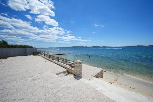 - une promenade sur une plage avec des gens dans l'eau dans l'établissement DʻArt Villa, à Bibinje