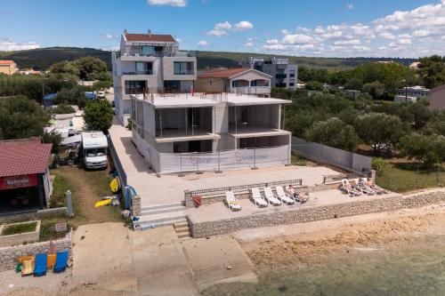 - une vue aérienne sur un bâtiment avec des chaises et une plage dans l'établissement DʻArt Villa, à Bibinje