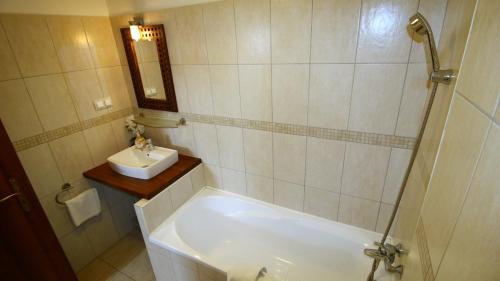 a bathroom with a bath tub and a sink at Gellény Lux Apartman in Gyula