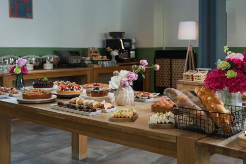 una mesa llena de diferentes tipos de postres y repostería en Hotel Admiral Lugano, en Lugano