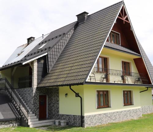 une maison avec un toit noir et jaune dans l'établissement Pokoje Gościnne, à Niedzica