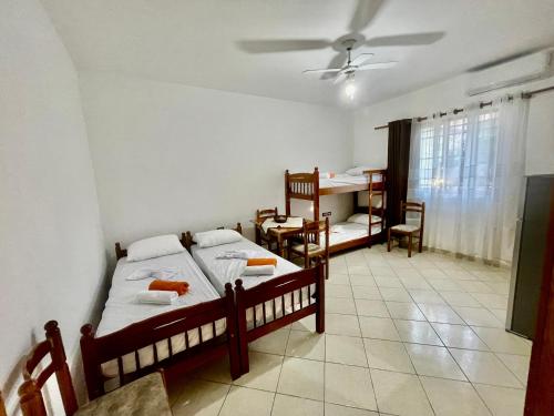 1 Schlafzimmer mit 2 Betten, einem Tisch und Stühlen in der Unterkunft Xhou's Home in Shkodra