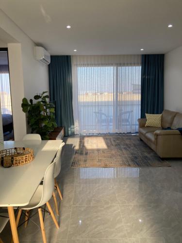 uma sala de estar com uma mesa e um sofá em Urban Awe Apartment- Setlhoa em Gaborone