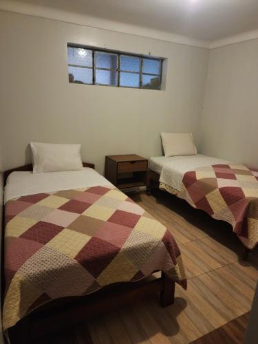 een kamer met 2 bedden en een raam bij Hostal Johumaji in Chachapoyas