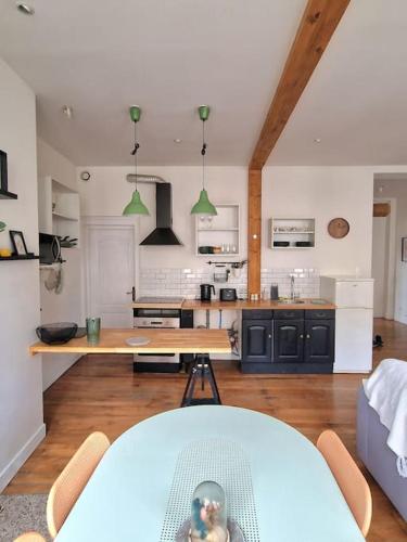 Il comprend un salon avec une table et une cuisine. dans l'établissement Magnifique Appartement - Driant, à Troyes