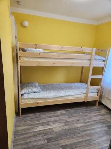 2 stapelbedden in een kamer met een gele muur bij Svitene apartmets in Svitene