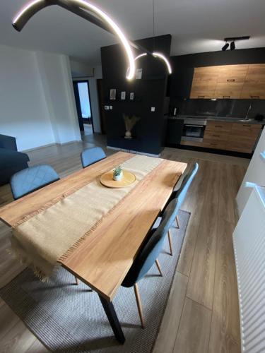 Cette chambre comprend une table en bois et une cuisine. dans l'établissement APARTMENT 7 -Free Garage- SARAJEVO -Dobrinja- -Ilidza- -Center-, à Sarajevo