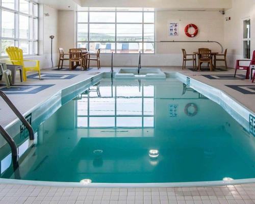 une piscine d'eau bleue dans un bâtiment dans l'établissement Quality Inn, à Moncton