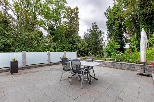 een patio met een tafel en stoelen en een hek bij Ferienwohnung Milita in Lörrach