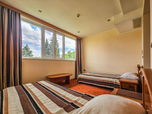 a hotel room with two beds and a window at Garni Hotel BaMBiS in Podgorica