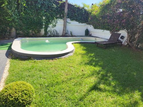 uma piscina com um banco num quintal em VILLA ADAM TANGIER em Tânger