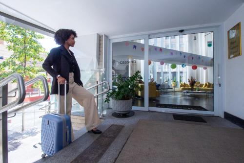 a man walking with a suitcase in a building at Hotel Cassino Tower São José do Rio Preto by Nacional Inn in Sao Jose do Rio Preto