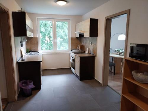 a kitchen with a large window and a sink and a stove at Krásny apartmán v centre Rožňavy in Rožňava