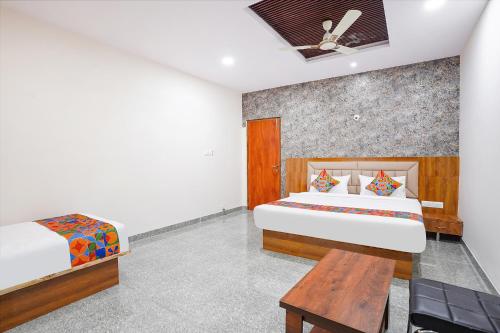 FabHotel Platinum Palace - Nr Magadi Main Road في بانغالور: غرفة نوم بسريرين وطاولة