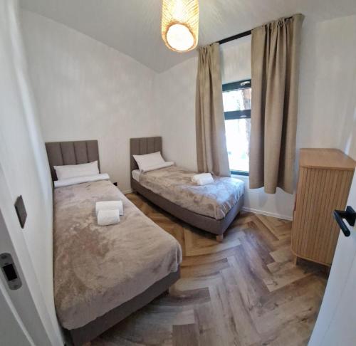 a bedroom with two beds and a window at FLY House Łeba in Łeba