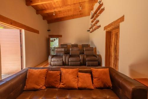 a living room with a brown leather couch in a room at Vistas Tapalpa in Tapalpa