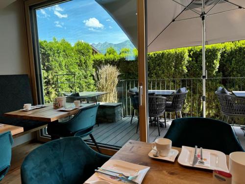 een restaurant met een tafel en stoelen en een groot raam bij Hotel Garni Landhaus Gitti in Zell am See