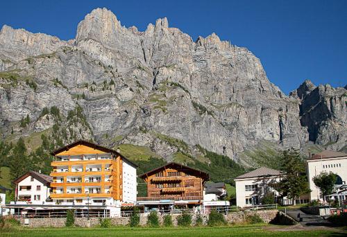 budynek przed dużą górą w obiekcie Hotel Römerhof w mieście Leukerbad