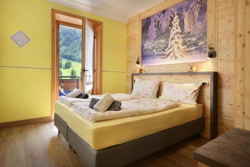 een slaapkamer met een bed met een schilderij aan de muur bij Baita La Fonte in Livigno