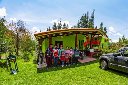 een groep mensen die voor een huis staan bij Happy Land Valle Sagrado in Urubamba