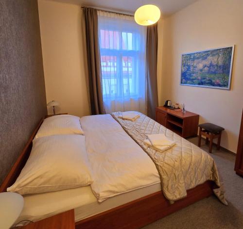 een slaapkamer met een groot bed en een raam bij Kafka Prague rooms in Praag