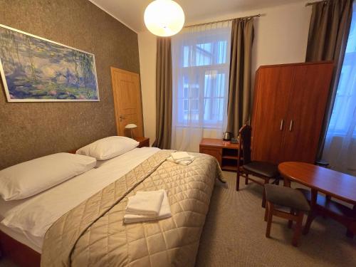 een hotelkamer met een bed, een tafel en een bureau bij Kafka Prague rooms in Praag