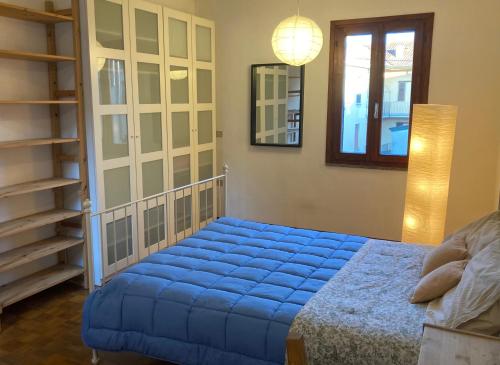 a bedroom with a blue bed and a mirror at Casa Express tra Como e Milano in Saronno