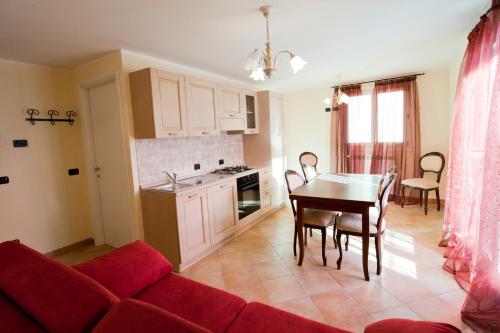 a living room with a red couch and a table at Residence La Corte in Vezza dʼOglio