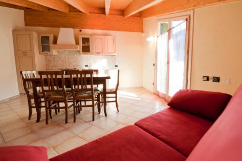 a living room with a couch and a table and chairs at Residence La Corte in Vezza dʼOglio