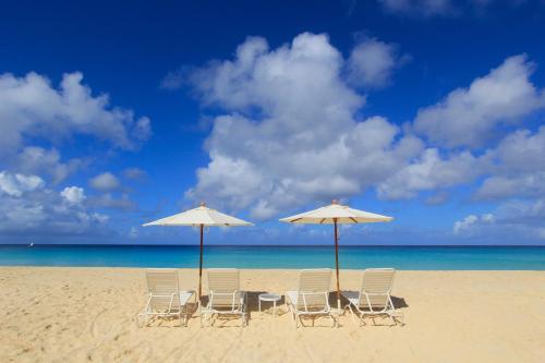 - un groupe de chaises longues et de parasols sur une plage dans l'établissement Carimar Beach Club, à Meads Bay